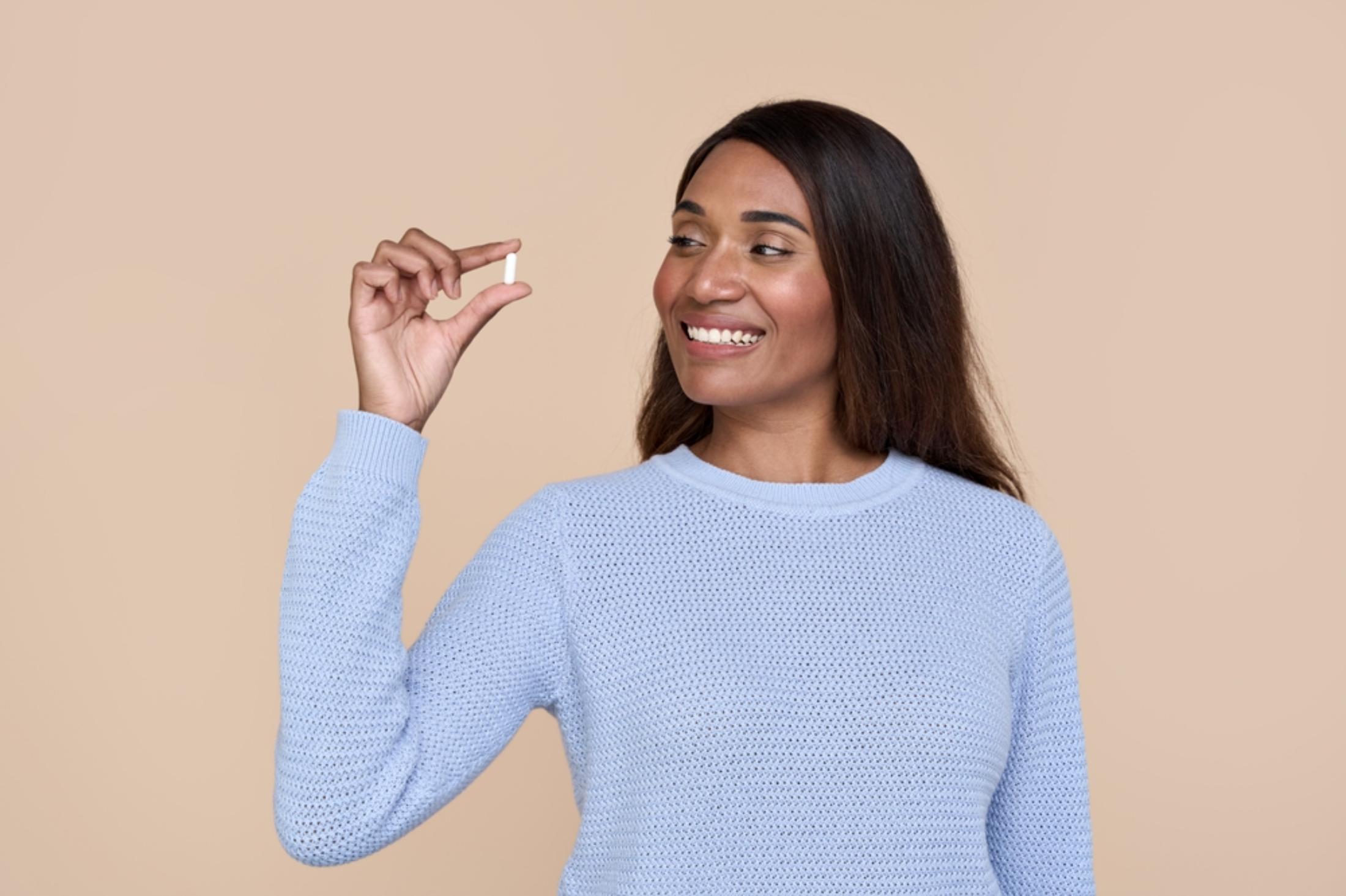 Woman holding a pill
